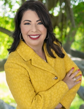 Cass in the nature with yellow suit smiling at the camera