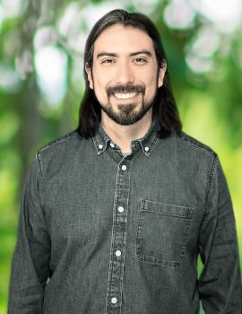 Hector standing up with black clothes smiling at the camera