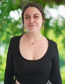 Paola smiling at the camera with black sweater